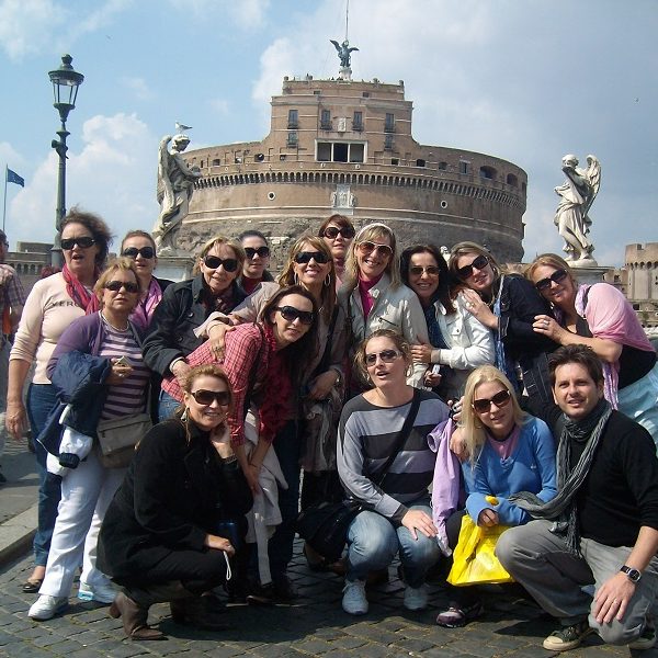 A group of people standing in front of a crowd posing for the camera - Castel Sant'Angelo